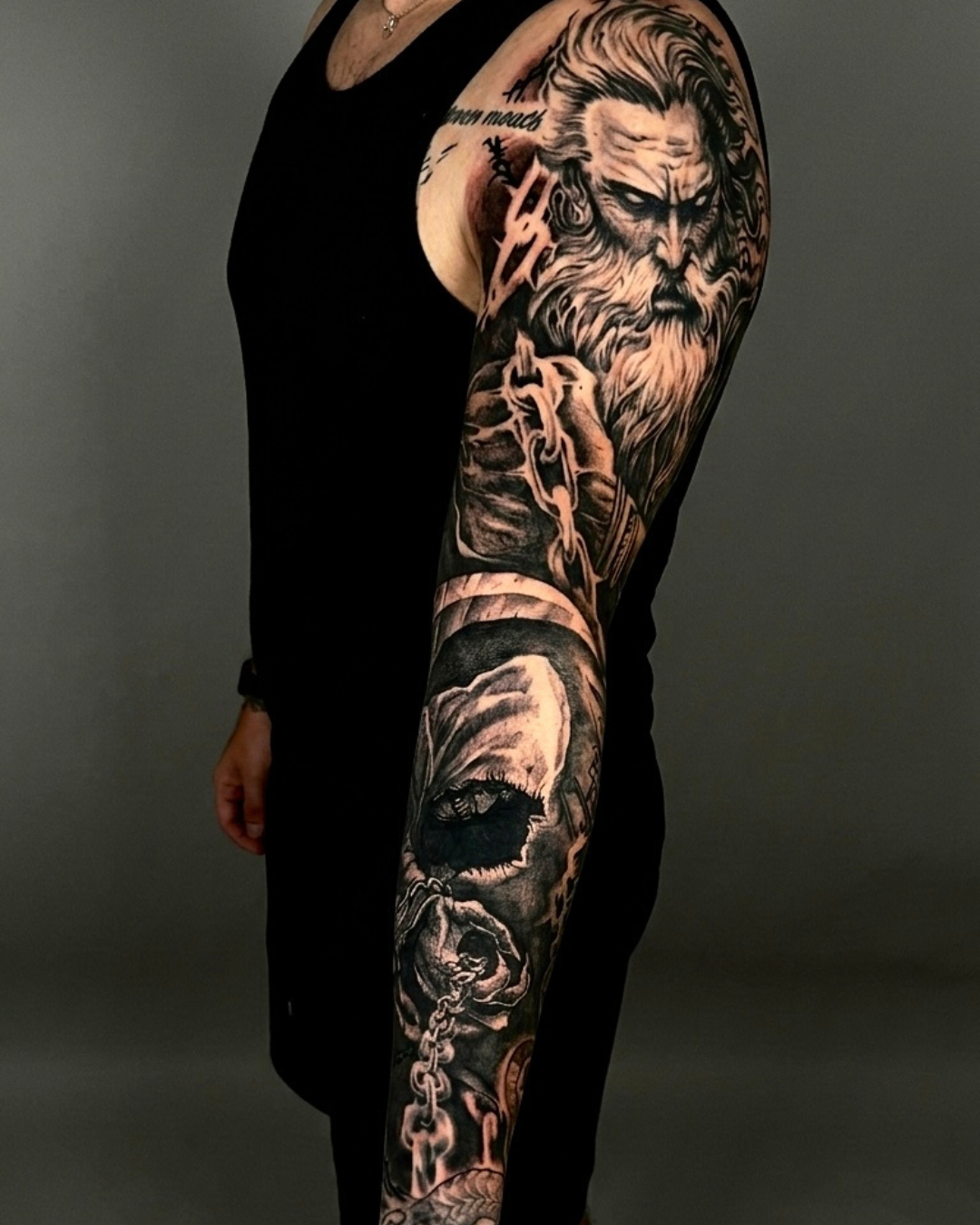 Tatuagem realista em preto e cinza no braço com figura mitológica e composição personalizada